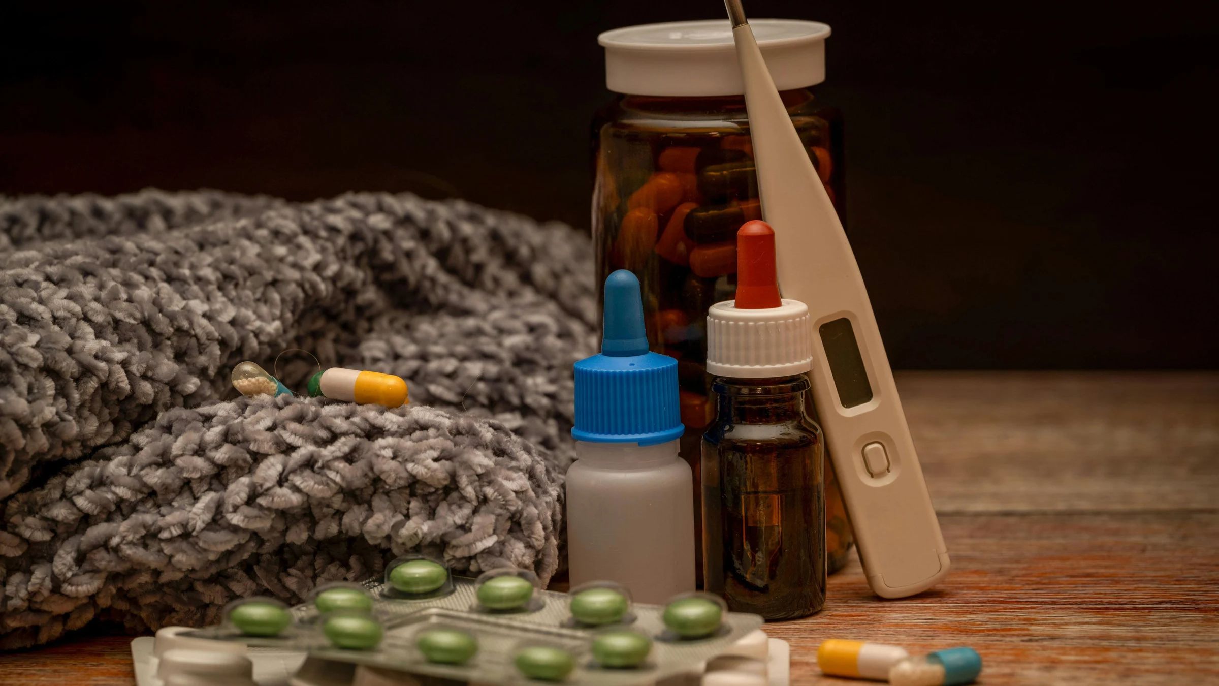 A kitchen counter at night with medications and unopened mail